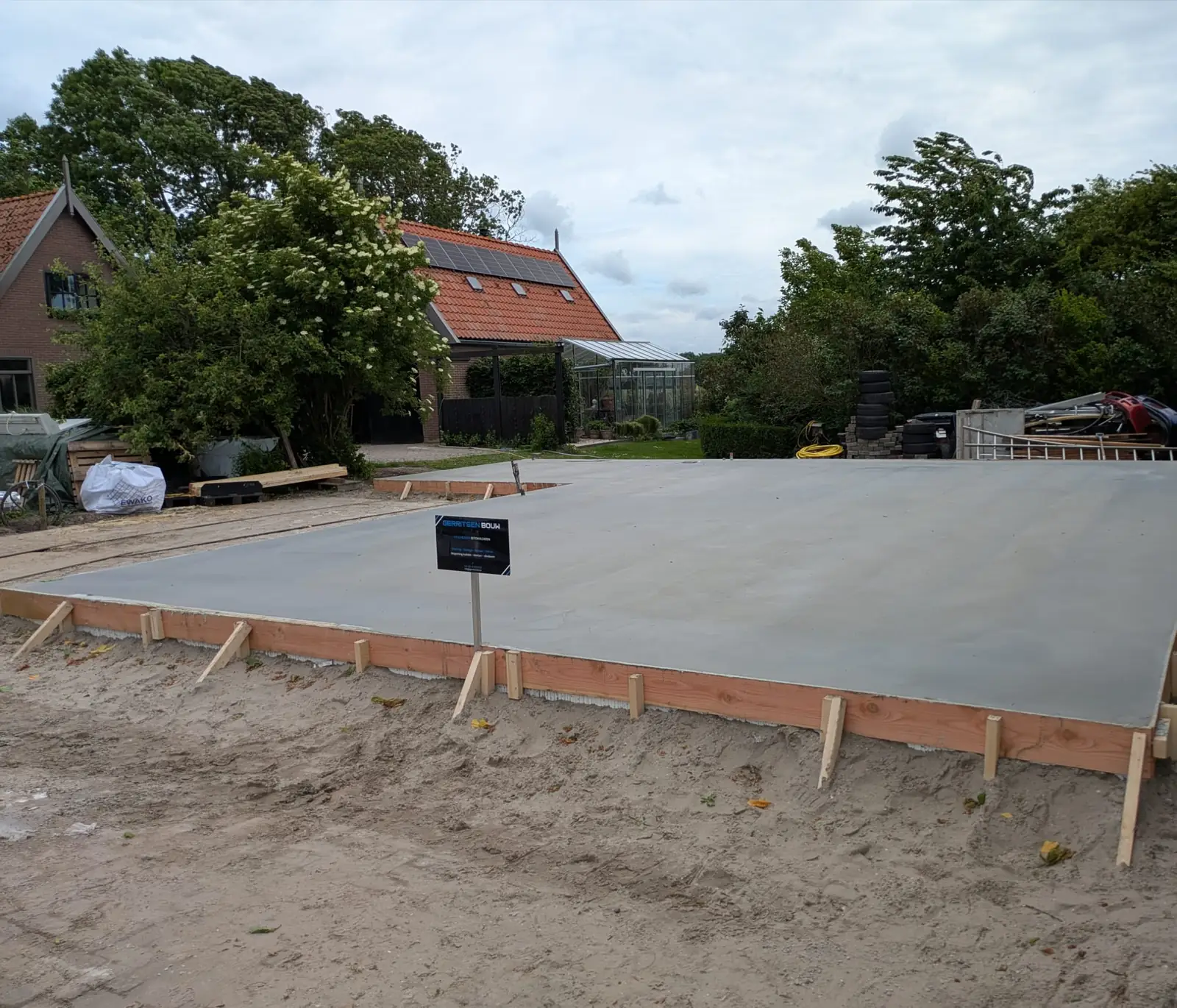 Afgewerkte betonvloer met houten bekisting in een achtertuin